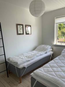 ein Schlafzimmer mit zwei Betten und einem Fenster in der Unterkunft Charming House With Sea View And Large Plot in Sandkås