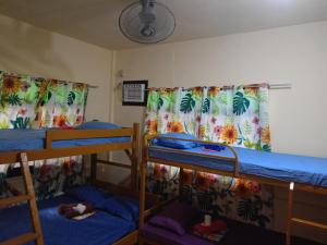 a room with two bunk beds and a curtain at Cabugao Lodge in El Nido