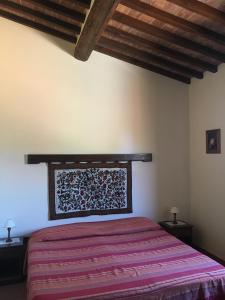CollesanoにあるLa Casa del Monte d'Oroの木製の天井が特徴のベッドルーム1室(ベッド1台付)