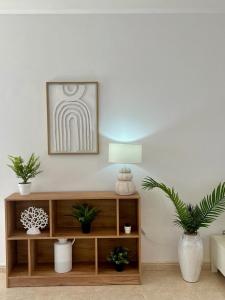 a living room with a shelf with plants and a lamp at Villa o Vilar in Playa Blanca