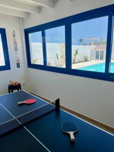 a ping pong table in a room with a pool at Villa o Vilar in Playa Blanca