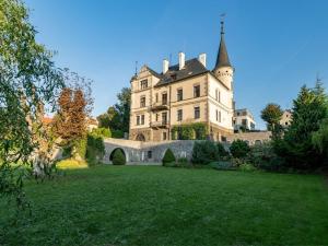 a large castle with a green lawn in front of it at Vila Černý leknín in Tábor