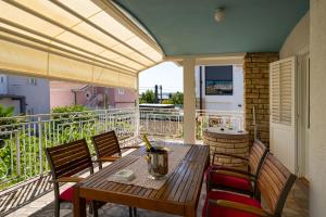 a patio with a table and chairs on a balcony at MY DALMATIA - Vacation house Maslenica with sea view terrace in Šarić