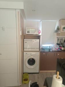 a kitchen with a washing machine and a microwave at Mobile home in Fabras