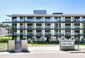 a building with a sign in front of it at ApartMare in Mrzeżyno