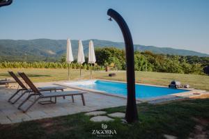 a swimming pool with two chairs and umbrellas at Boutique Villa Zagorka in Stubicke Toplice +66 photos