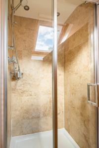 a bathroom with a shower with a glass door at River Cottage - Idyllic & Chic Retreat, Wye Valley in Newland