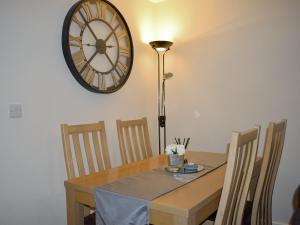 une table à manger avec une horloge sur le mur dans l'établissement Mountain View, à Blaenau Ffestiniog