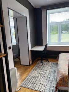 a room with a desk and a window and a bed at Karula Stay - 2 Bedroom City Centre Apartment in Antsla