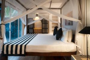 a bedroom with a canopy bed with a window at White parrot beach villa in Ambalangoda