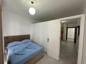 a bedroom with a bed with a blue blanket on it at Summer Apartments in Shengjin in Shëngjin