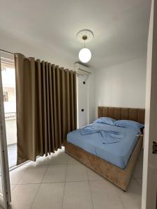 a bedroom with a bed and a window with curtains at Summer Apartments in Shengjin in Shëngjin