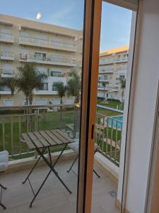 a balcony with a table and a view of a building at Chaleureux appartement in Bouznika