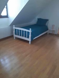 Bett in einem Zimmer mit Holzboden in der Unterkunft Le gîte des Aubèles in Saint-Félix-de-Lunel
