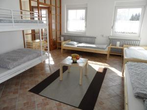 a room with two bunk beds and a table at Penzion SPICAK in Železná Ruda