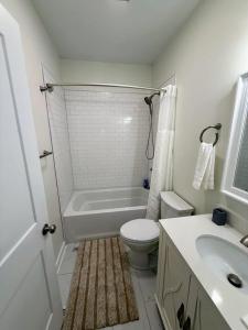 a bathroom with a tub and a toilet and a sink at Newly Renovated 2 Bedroom - B in Durham