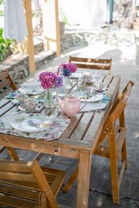 a wooden table with plates and flowers on it at Casa Viola Bed and Breakfast Dimora di campagna in Calice Ligure +54 photos