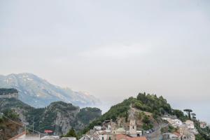 a town on a hill with mountains in the background at Dimora la Fenice Suite Smeraldo in Amalfi