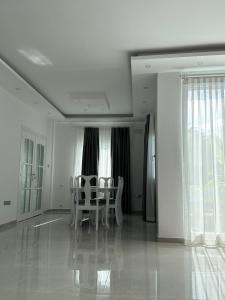 a dining room with white chairs and windows at Glapsides Sea Villa in Famagusta +16 photos
