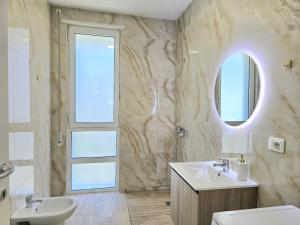 a bathroom with a sink and a mirror at Holiday Apartment in San Pietro Residence 304 in Lalzit Bay +26 photos