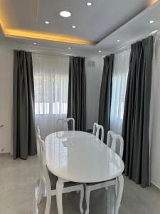 a dining room with a white table and chairs at Glapsides Sea Villa in Famagusta