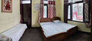 a bedroom with two beds and two windows at aashirwad homestay in Bhowāli