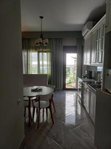 a kitchen with a table and chairs and a dining room at Peti's Apartment in Prinos