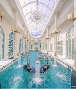 une grande piscine avec un lustre dans un bâtiment dans l'établissement Grand Florida Beachfront Pattaya, à Na Jomtien