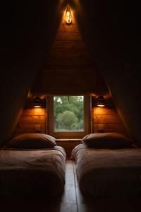 a attic room with two beds and a window at Siódme Niebo domek w górach in Duszniki Zdrój