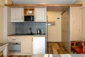 a small kitchen with white cabinets and a sink at Kadıköy Modern Loft & Equipped Stay in Istanbul