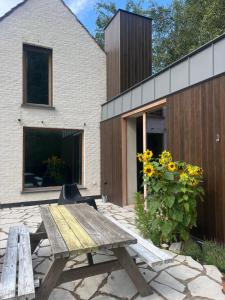 einem Picknicktisch aus Holz vor einem Haus in der Unterkunft Duinenhuis Edgard in Koksijde