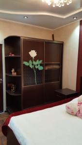 une chambre avec un lit avec une fleur peinte sur le mur dans l'établissement Batumi Flat, à Itʼkhvisi