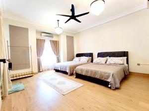 a bedroom with two beds and a ceiling fan at The White House Nilai Impian in Nilai