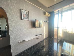 La salle de bains est pourvue d'un mur en carrelage noir et blanc. dans l'établissement Batumi Flat, à Itʼkhvisi