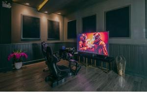 un salon avec une télévision à écran plat et des chaises dans l'établissement Grand Florida Beachfront Pattaya, à Na Jomtien 2 autres photos