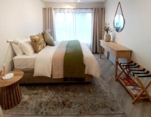 a bedroom with a large bed and a window at Platform 133 2 Tabak in Paarl +3 photos