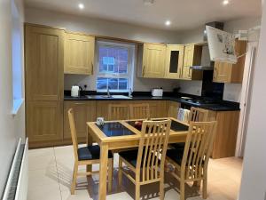 a kitchen with wooden cabinets and a table and chairs at Carnbeg Green 