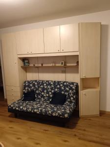 Un sofá en una habitación con armarios blancos. en Val di Luce Home, en Abetone 15 fotos más