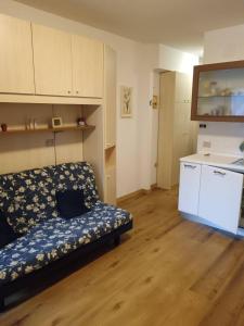 Una sala de estar con un sofá y una cocina. en Val di Luce Home, en Abetone