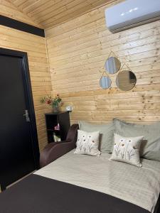 a bedroom with a bed and a wooden wall at Cozy Lake House in Cinciş +20 photos
