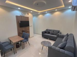a living room with couches and a table and a tv at أبراج المصايف للشقق المخدومة in Taif
