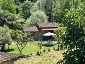ein Haus mit einem Tisch und einem Sonnenschirm im Garten in der Unterkunft Casetta Girasole - Monterchi in Monterchi + 13 Fotos
