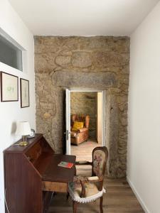 a room with a desk and a couch in a stone wall at Casa do Albano in Viana do Castelo +139 photos