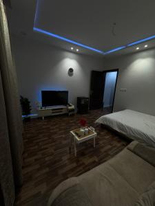 a living room with a bed and a couch and a tv at استديو 1 in Jeddah
