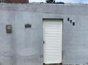 a white garage door on the side of a building at Casa familiar perto da Escola São Cristovão in Garanhuns +5 photos