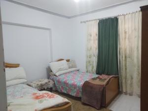 a small bedroom with two beds and a window at Gadou Rooms in Port Said