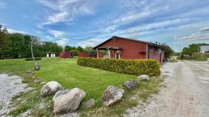 a small red house with rocks in front of it at Pühajõe Puhkemaja in Pühajõe +62 photos