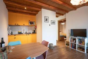 a kitchen and dining room with a table and a television at Casa da Praça in Freixo de Numão