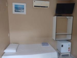 a small room with two beds and a tv at Hotel Avenida in Acailandia