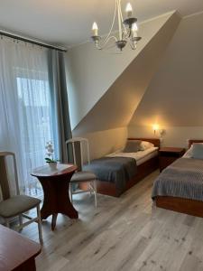 a room with two beds and a table and a bed sidx sidx sidx at Apartamenty i pokoje Sosnowa 4 Dębki in Dębki